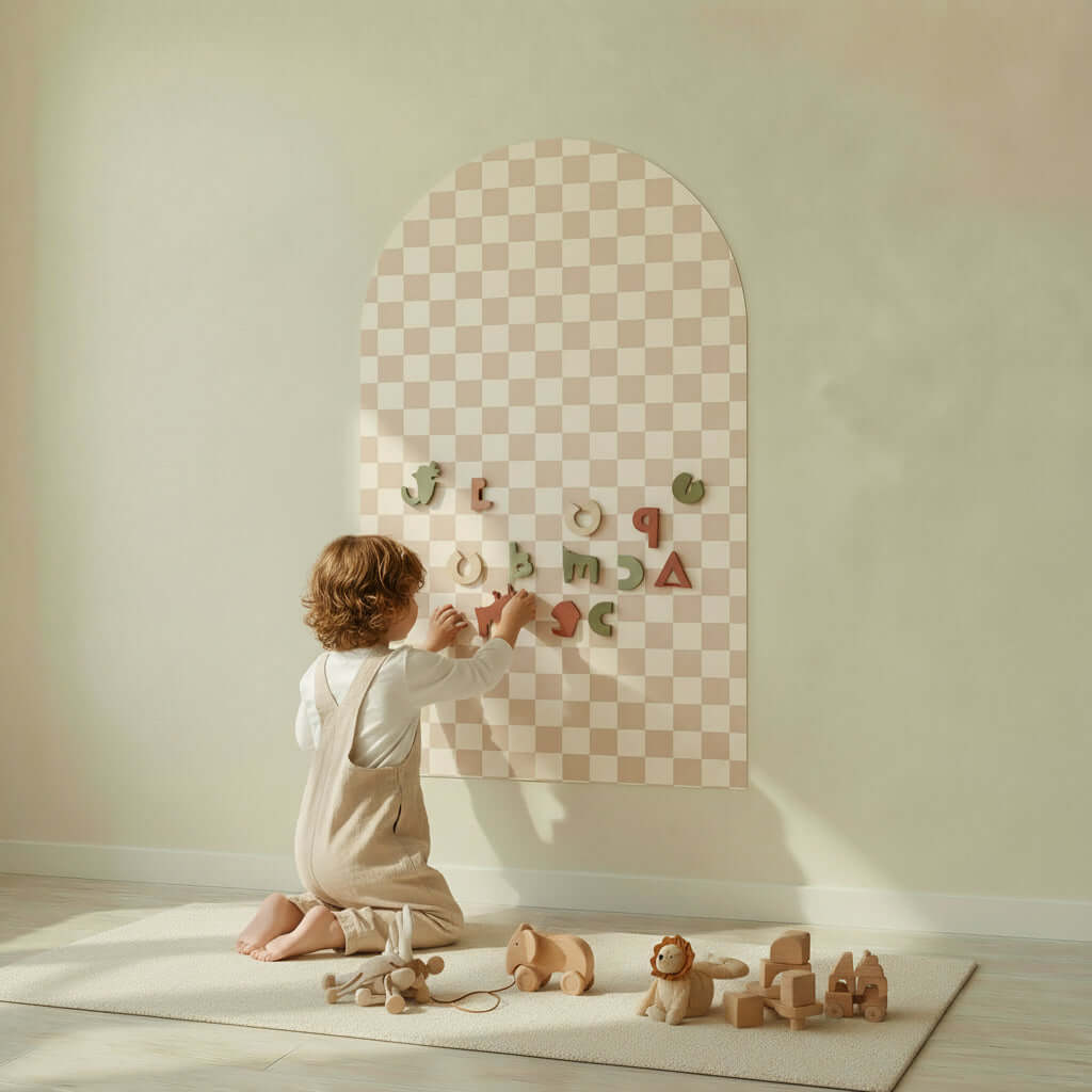 Child playing with letters on a beige checkered magnetic board for children, showcasing creativity and learning.